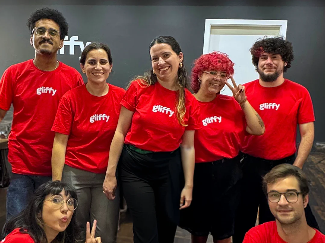 Equipe da Gliffy reunida, todos de camiseta vermelha com a logo da agência